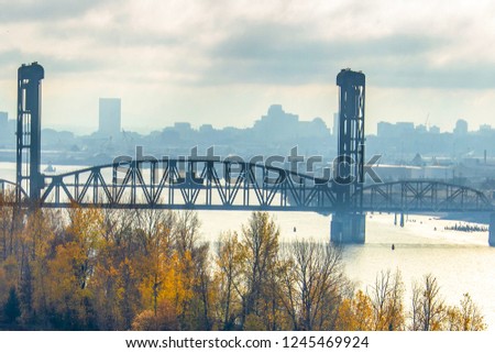 A view of a steel bridge and the Portland Oregon hazy skyline.