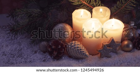 Four burning Advent candles and snow . Christmas background.