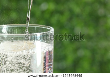 a cup of carbonated drink in a green background