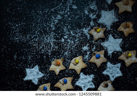 Coconut star shaped Christmas cookies decorated with coconut chips on a dark background