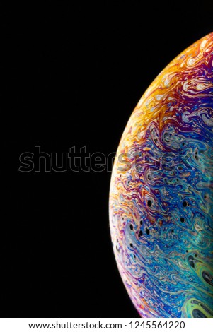 Macrophotograph of a colorful soap bubble that look like a planet in space