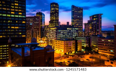 Illuminated city lights in Denver , Colorado , USA at Night Downtown City glowing Nightscape Skyline of the Mile High City Skyscrapers and office buildings rising up into the night sky
