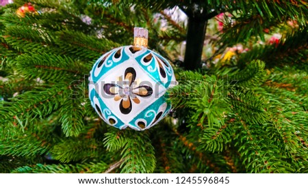 Beautiful Christmas ornaments. Christmas decoration in the form of a colorful ball, in the background, branches Christmas tree.