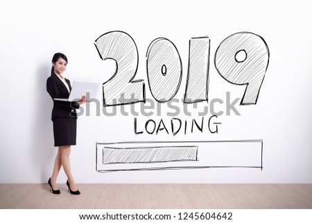 business woman using laptop computer with 2019 text and white wall background