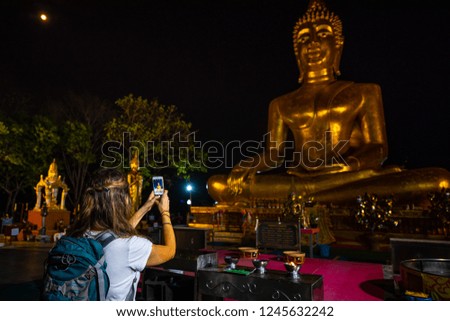 Backpacker takes a picture with smarphone. Giant Buddha Statue Pattaya City Thailand