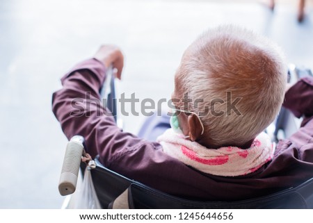 Old man with white hair  on a wheelchair at the hospital.
