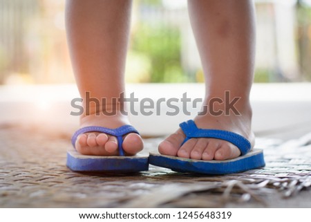 Girl's feet wearing flip-flops at  home