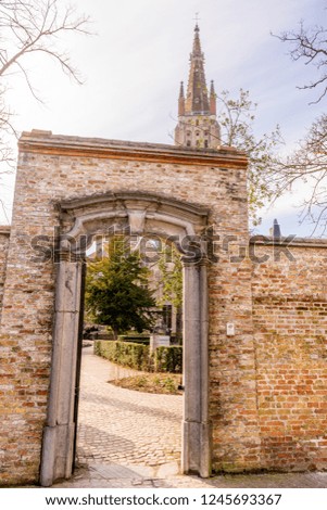 Belgium, Bruges, a open door in front of a brick building with churh of lady in background