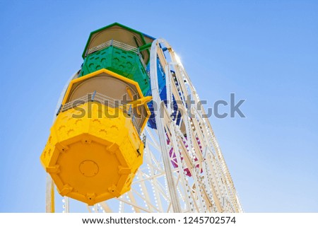 Close up picture of colorful Ferris Wheel against blue sky