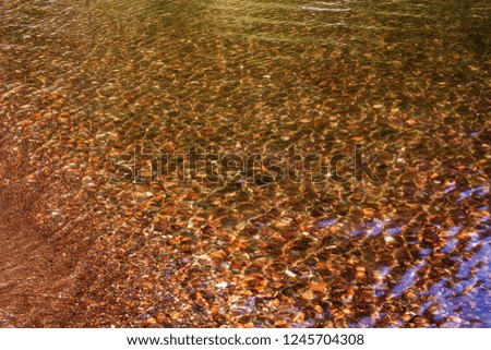 Blurred background with stones under the transparent water of Teletskoye Lake