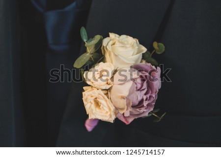 Rose boutonniere on the groom's jacket close-up.