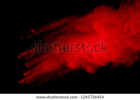 abstract red powder explosion on black background.abstract red powder splatted on black background. Freeze motion of red powder exploding.