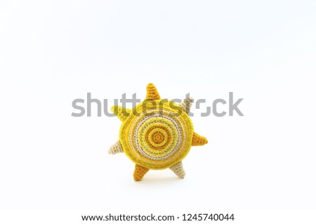 Little knitted sun for baby on white background, knitted toy