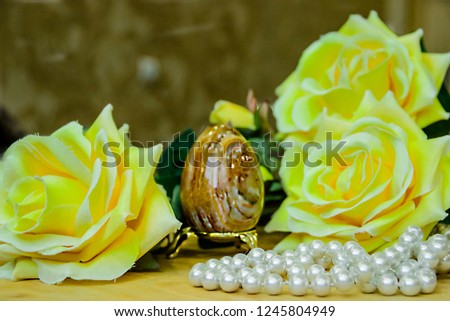 pictured in the photo artificial Easter brown egg and artificial yellow roses