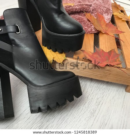 Black women's leather heeled boots on a wooden box