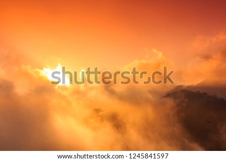 Amazing landscape with mountains sea blue sky sun and beautiful colorful red clouds at sunset in mountains.