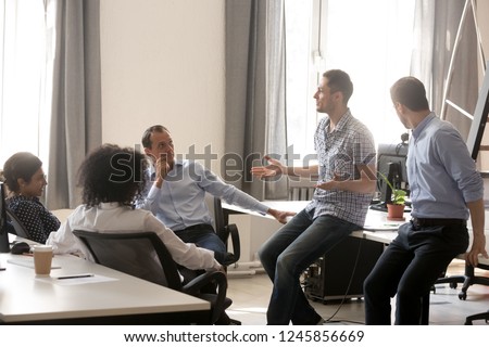 Diverse colleagues sitting in circle, talking on business training with coach, multiracial team employees discussing business strategy, ideas, involved in teambuilding activity, listening trainer Royalty-Free Stock Photo #1245856669