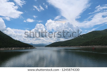 blue sky with clouds and Iridescence over the dam,reflection,mountain