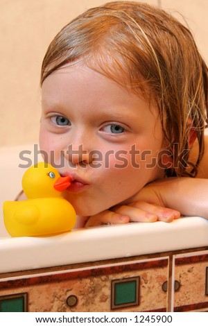 Little girl kissing bath duck