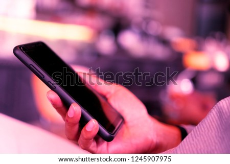 Woman hand using smartphone and laptop with cafe shop colorful highlight shade to object beautiful background. Business, financial, trade stock maket and social network concept.