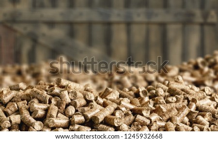 Close up on a pile of compressed wood pellets for use as an eco-friendly renewable organic biofuel or mulch in the garden over a white background