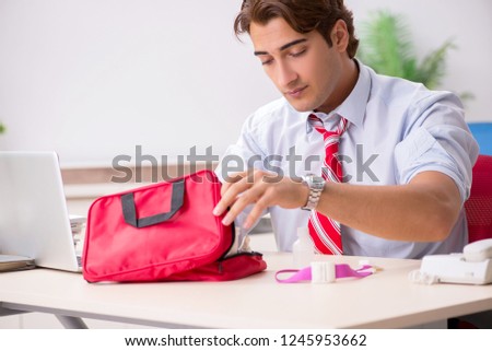 Man with first aid kit in the office