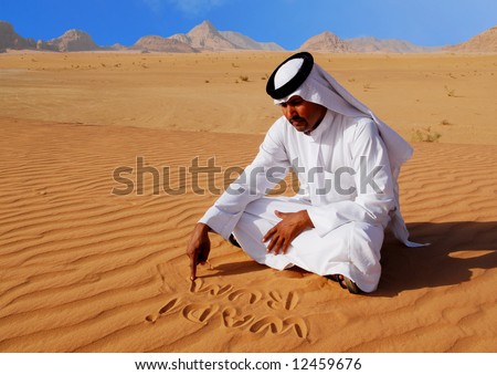 Traditional arabic man writing in the sand in Wadi Rum desert, Jordan