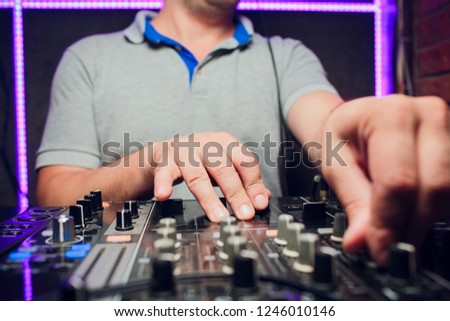 DJ remote, turntables, and hands . Night life at the club, party.