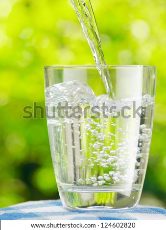 Glass of water on nature background.