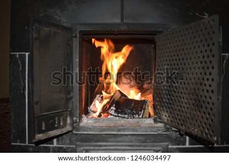 Fire whit Fireplace in the picture Fire in a fireplace flames playing, cold weather outside fire collar heat warmth heater dark background.