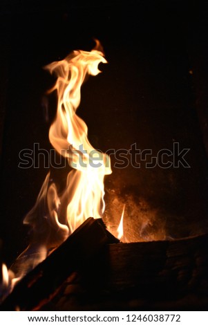 Close-up Picture of fire in a fireplace. Fire in a fireplace flames playing, cold weather outside fire collar heat warmth heater dark background.
