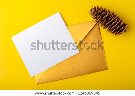 Mock-up letter or postcard with a gold envelope on a yellow background. Copy space