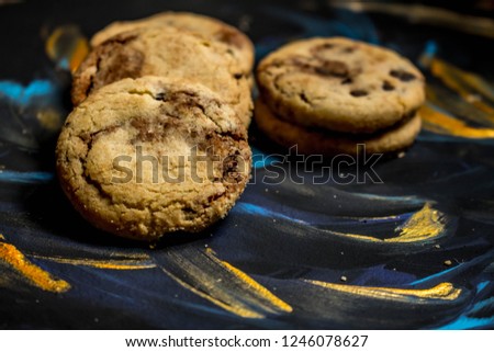 Vanilla cookies with chocolate chips on a blue and gold background. Sweets for the snack.