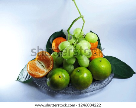 Colorful set of fresh fruits (bunch grape,orange) were decorated in a glass dish.