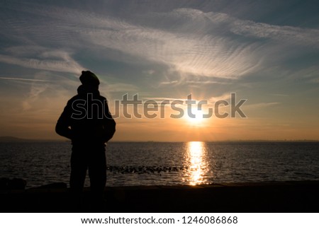 A person who enjoys the beautiful sunset on the beach.