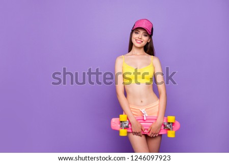 Gorgeous nice adorable good-looking lady in yellow top and pastel peach mini shorts make her toothy smile she stand isolated on shine purple background with copy space for text hold longboard in hands
