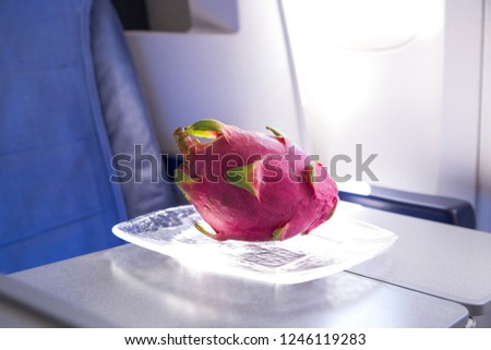 fresh pink dragonfruit on the table in the plane for dinner during flight to tropic country