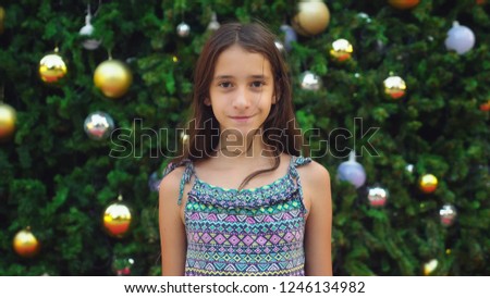 happy girl on the background of the Christmas tree and palm trees in a tropical city. The concept of New Year's travel to warm countries.