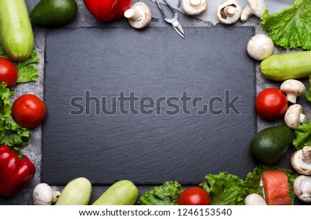Frame made with variety of fresh colorful vegetables and salmon and a blackboard with empty space. Top view, cooking process Royalty-Free Stock Photo #1246153540