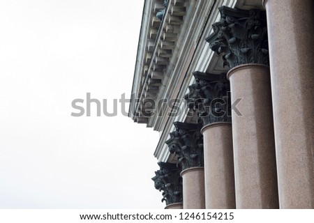 Granite columns of the facade of St. Isaac's Cathedral against the gray sky in St. Petersburg. Background. Copy space. Background. Side view from below. Copy space.