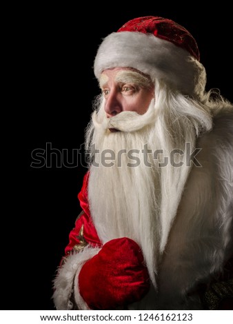 Santa Claus and Santa Claus on a black background. Santa Claus and Santa Claus majestic, looking amazed at the side, in profile against a black background.