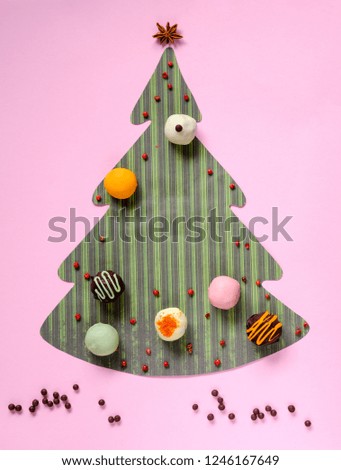 Festive background from color paper and tasty truffles. Christmassy background.