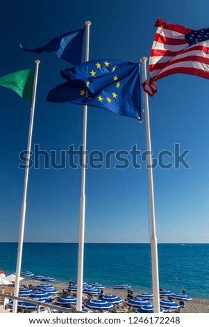 European and American flags flying in the background of the sky and the sea