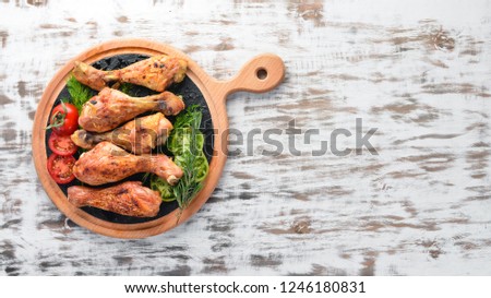 Baked Chicken legs on a white wooden background. Meat. Top view. Free copy space