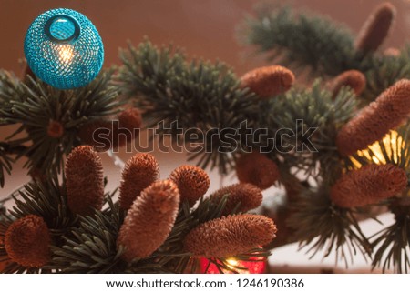 
Pine branch with cones and Christmas  light  on the paper background