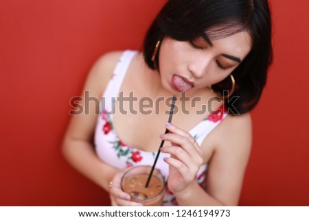pretty asian woman with coffee. Asian woman relaxing on couch with coffee.