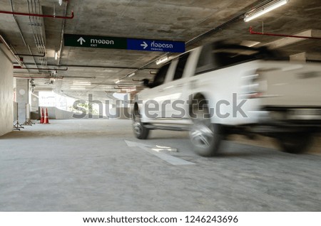 The car runs toward the exit. Of the parking building