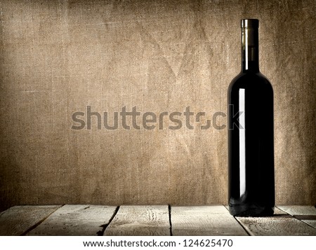 Black bottle of wine on the background of the canvas