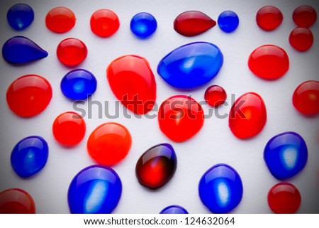 Red and blue  ink drops on paper with bright center spotlight and black vignette border frame