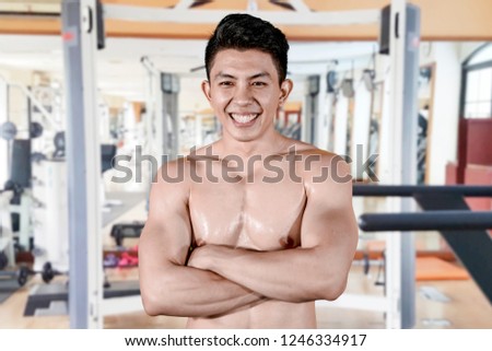 Picture of happy man folded his arms while standing in the gym center